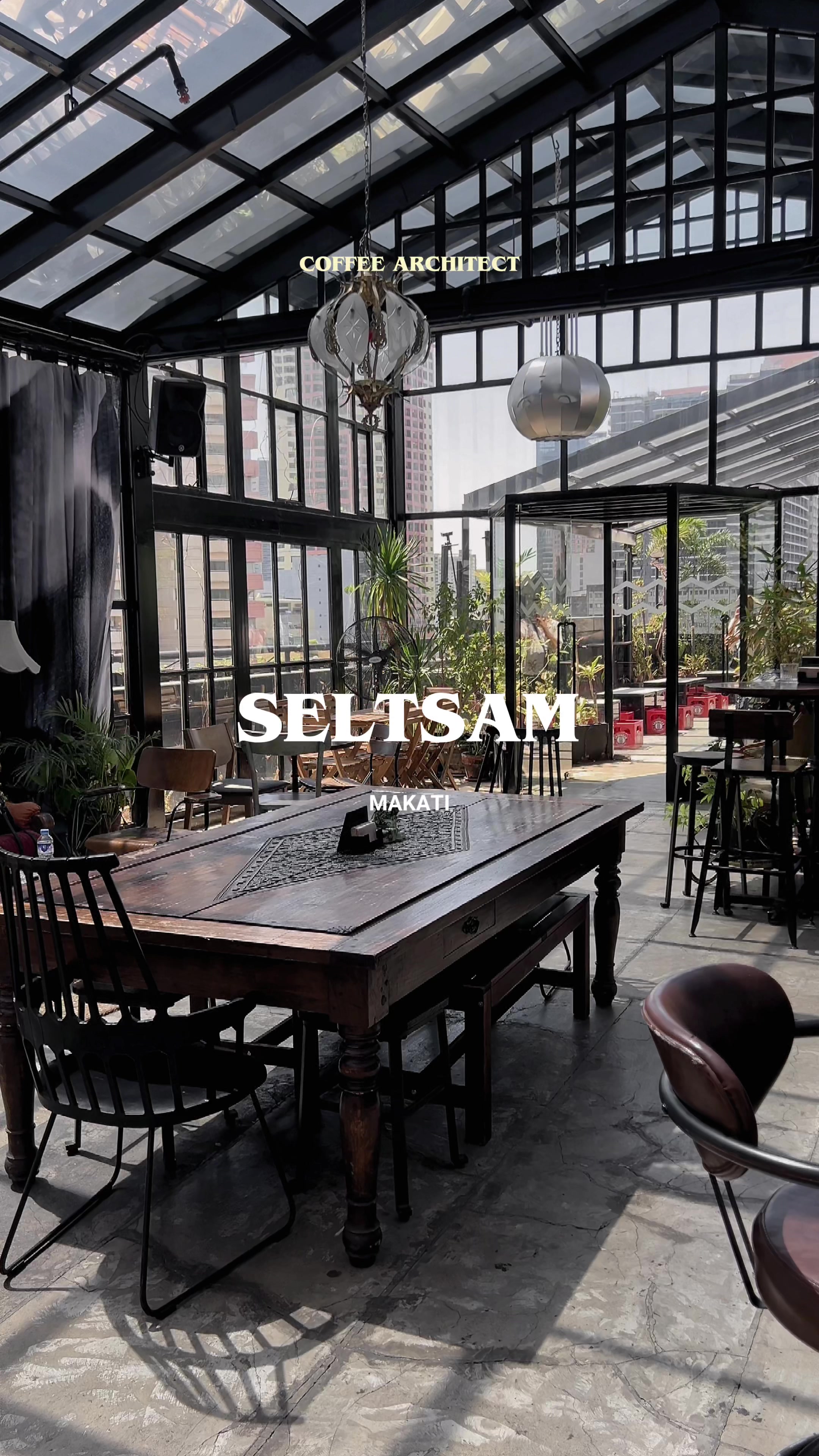 Seltsam glass house interior with vintage wooden tables and glass ceiling in Makati